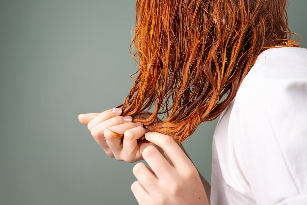 A
Pantagonar Shihuanuo detailed image showing a close-up of red hair being held by delicate hands against a neutral background.