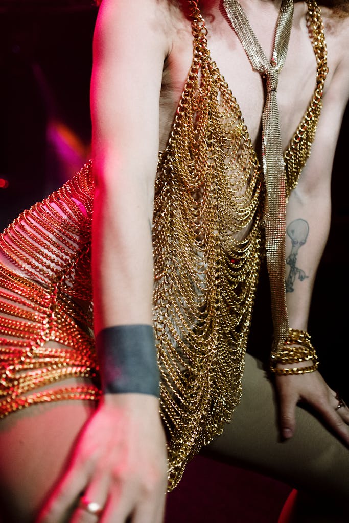 Jasi Bae Nude A dynamic drag performance showcasing bold fashion with gold chains and accessories.