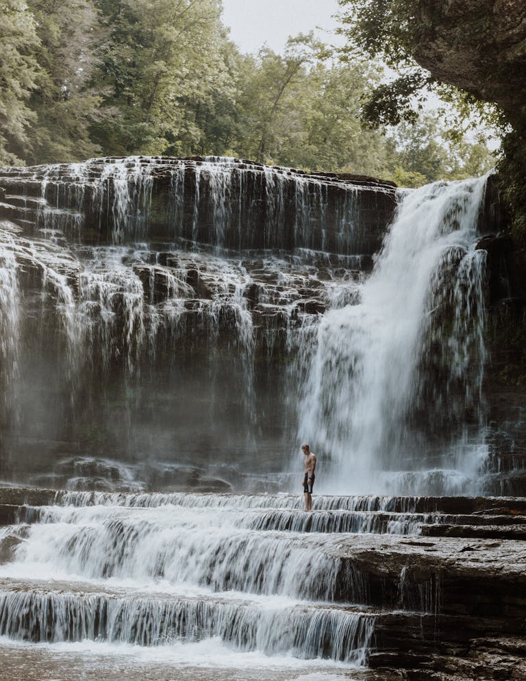 A stunning Heroines photo waterfall in Tennessee with a lone visitor experiencing its beauty.