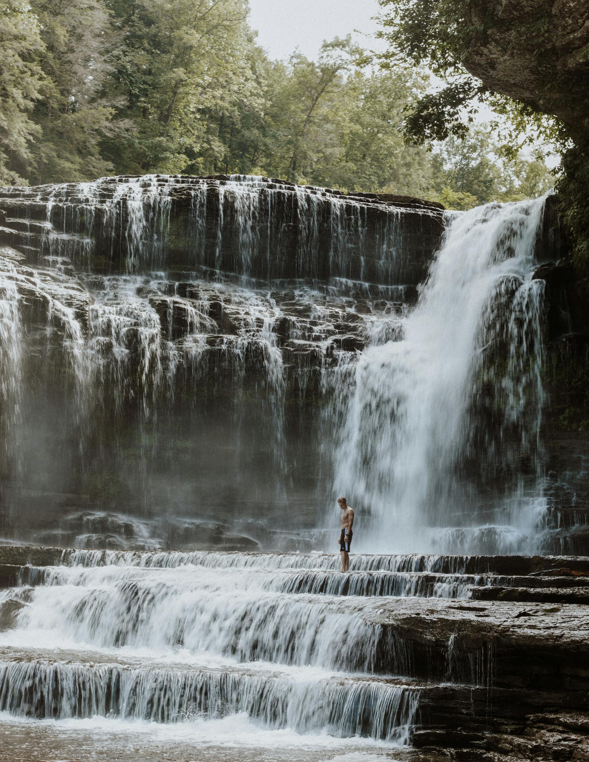 A stunning Heroines photo waterfall in Tennessee with a lone visitor experiencing its beauty.