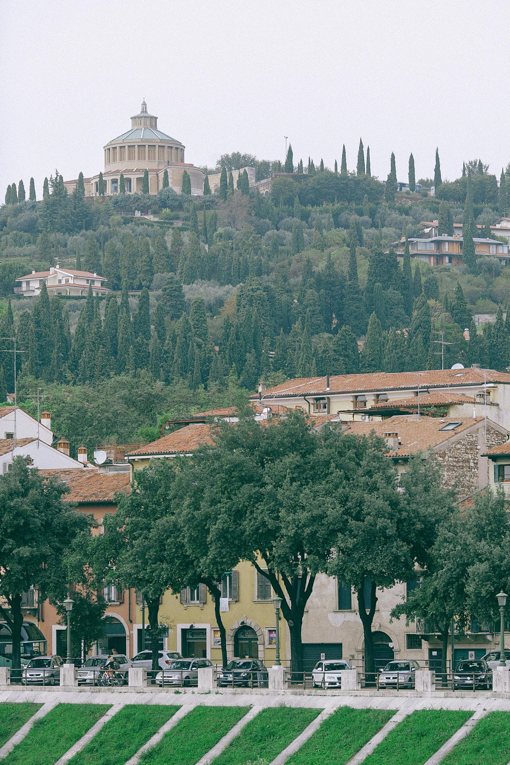 Uomo Cerca Uomo Verona Aged stone building with tower on top of green hill behind classic buildings
