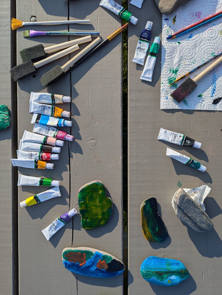 Nova Scola
Colorful acrylic paints and brushes arranged on a wooden table outdoors, showcasing a vibrant crafting setup.