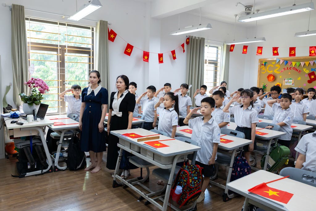 Classroom 15x Students and teachers in a classroom standing and saluting with flags displayed.