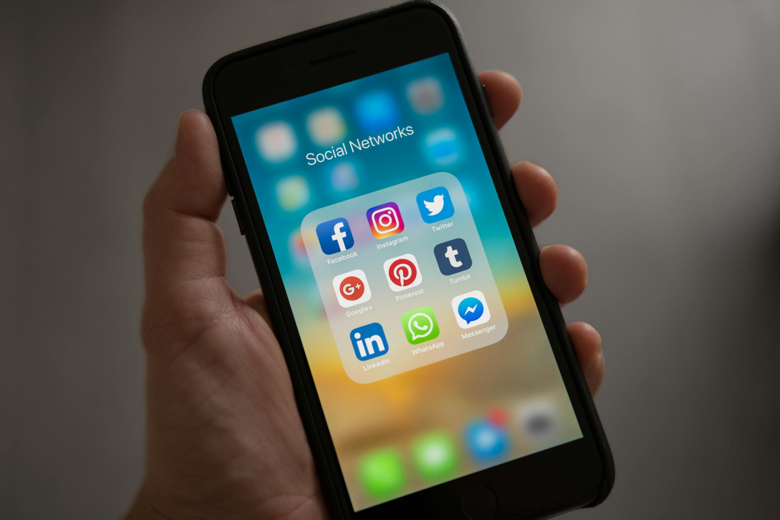 A Tamil aunty WhatsApp groups smartphone displaying various social media icons held in a hand, showcasing modern communication apps thebaddieshub.com