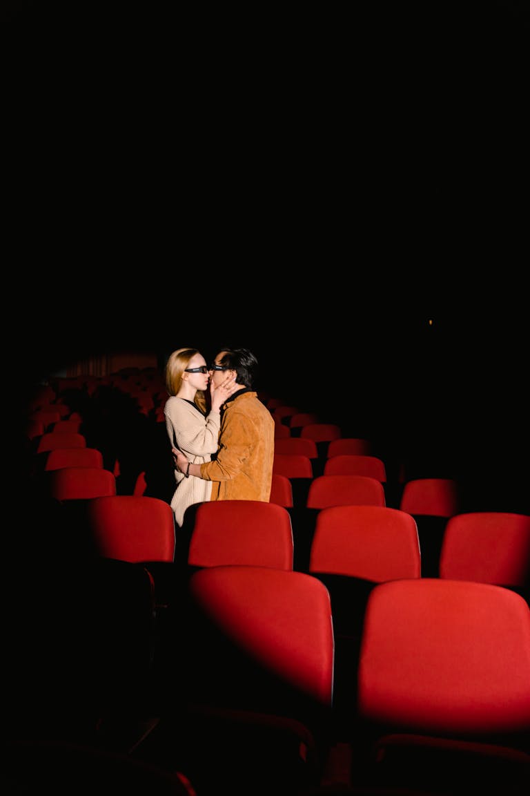 Aishah Sofey Leaks Couple embracing and kissing in an empty theater, highlighting love and affection.