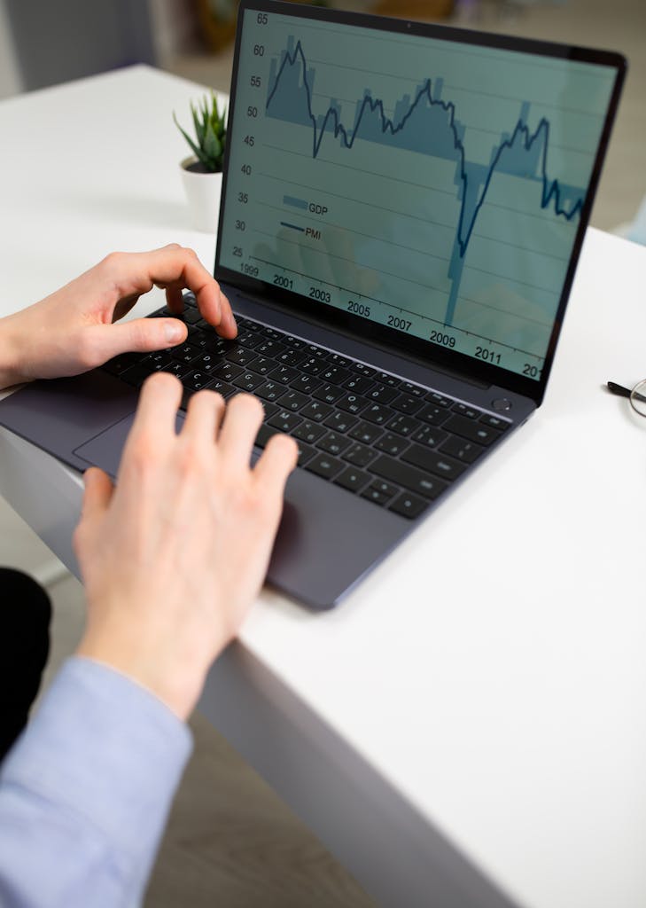 Smart Finance Tips and Updates for 2025 Crop unrecognizable male entrepreneur typing on laptop keyboard while preparing financial diagrams during work in office