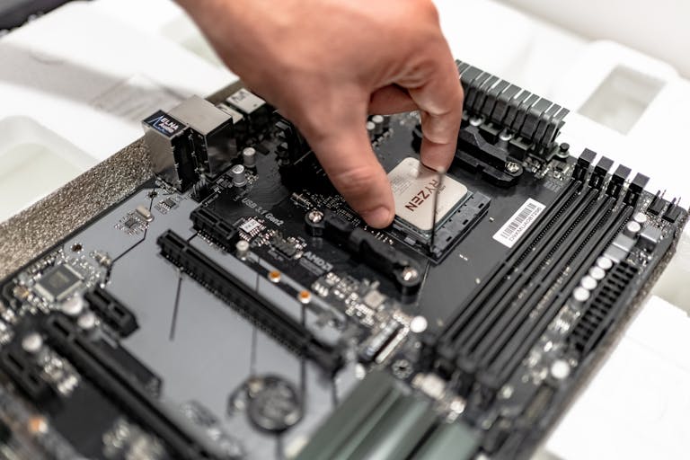 Link Slot gcslot.org Person's hand installing a CPU on a motherboard, showcasing PC maintenance and repair.