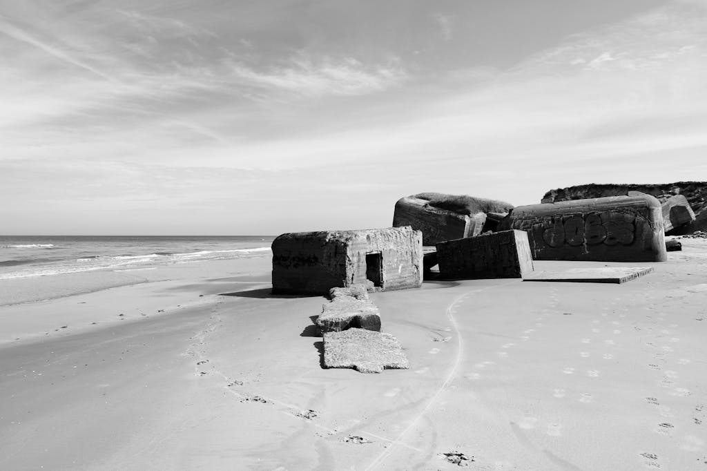 World War 2 Log: Monochrome view of a World War II bunker on a deserted Danish beach.