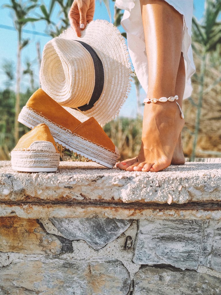 Lorax Pro Barefoot Shoes Relaxed summer day featuring straw hat, espadrilles, and anklet on stone ledge.