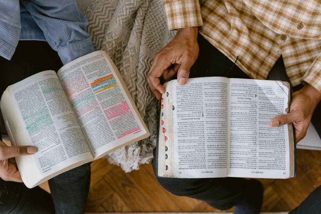 Sound Solutions Two adults reading religious texts with highlighted passages indoors, sharing a moment of learning and connection.