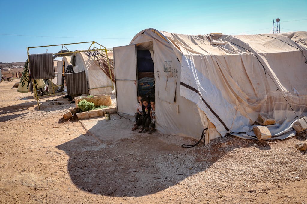 World War 1 Young children standing near tents in a refugee camp in Idlib, Syria. Focus on poverty and displacement.