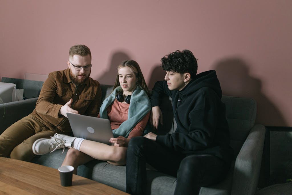 Dev to Baddies Young team discussing project on laptop in cozy office setting.