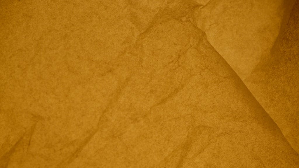 permanentad Close-up view of a crumpled yellow paper texture, ideal for backgrounds and designs.