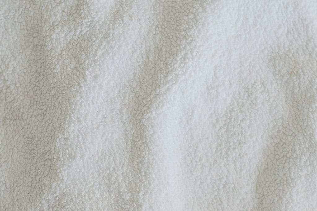 Fraboc Top view full frame of soft white towel fabric placed on table in light room