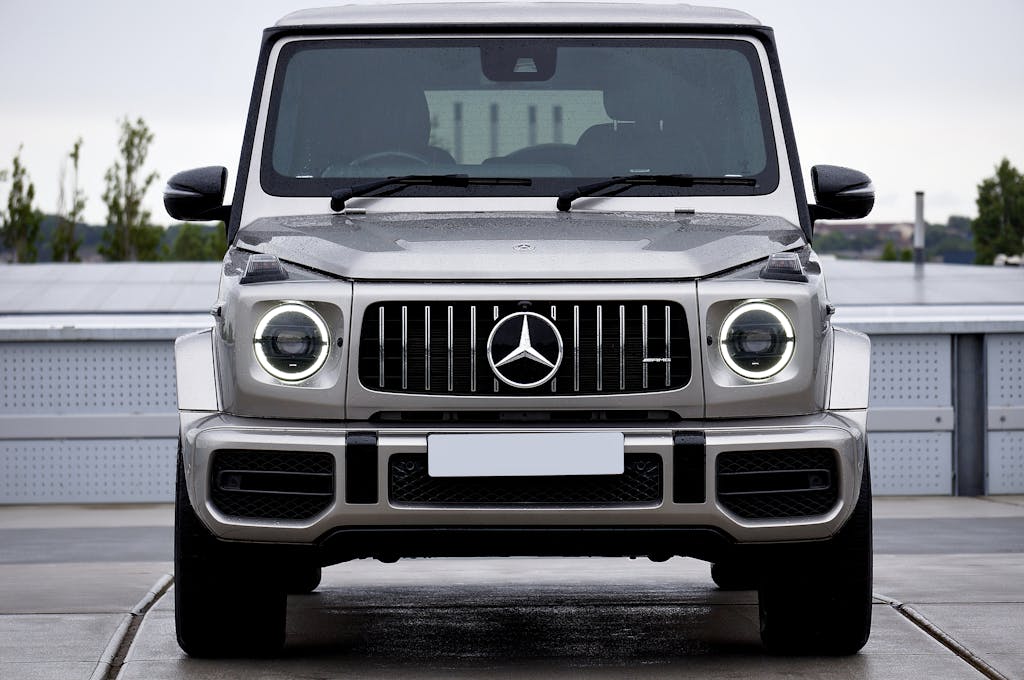 Unbanned G+ A sleek, gray luxury SUV prominently displayed on an outdoor driveway with a modern backdrop.