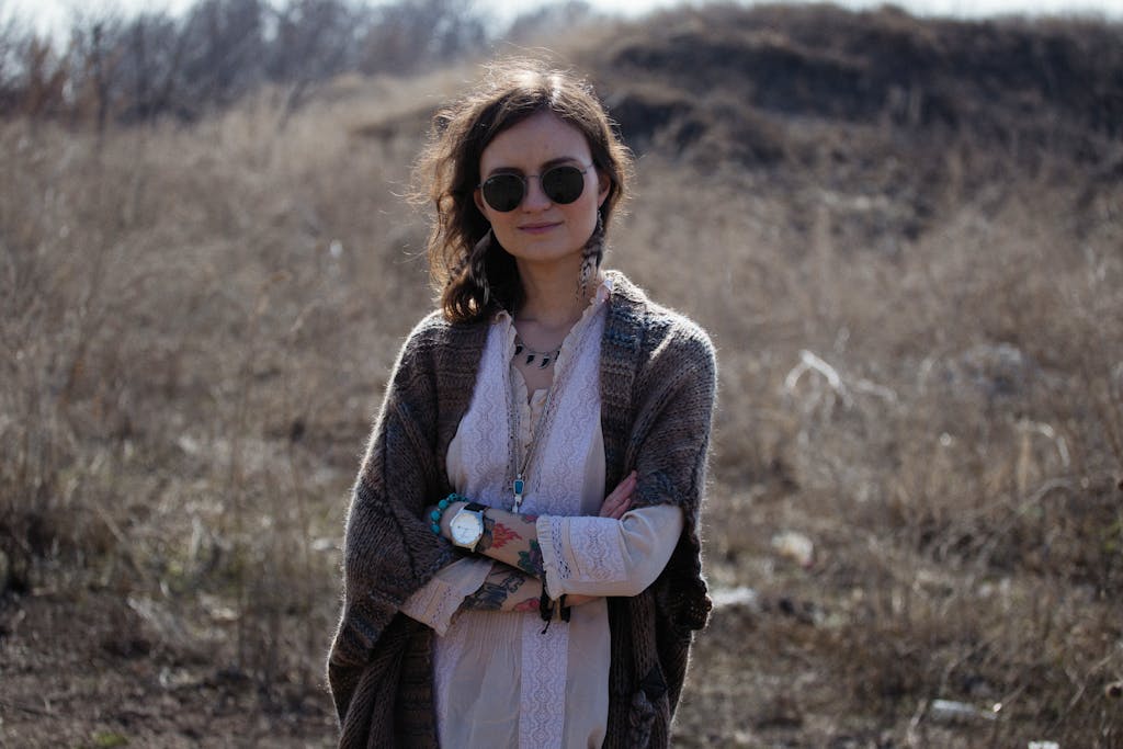 Carmela Clouth Fashionable woman outdoors in a white dress and knitted cardigan, embracing bohemian style.
